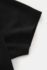 Close-up side view of the sleeve of the 04651/ A trip in a bag Poloshirt 'TP' schwarz, made of pure cotton piqué with a soft feel, regular fit, classic polo collar, smooth button placket, small woven label in side seam, and comfortable ribbed cuffs. <p>Ob