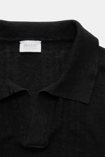 Close-up front view of 04651/ A trip in a bag Short sleeve knit polo 'Johnny' black showing the open collar strip and fine knit texture.

<p>Modern classic: This short sleeve knit polo by 04651/ A TRIP IN A BAG has a clean striped look that makes a stylis