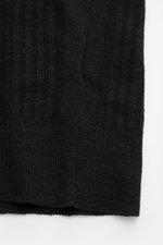 Close-up front view of the ribbed hem on the 04651/ A trip in a bag Short sleeve knit polo 'Johnny' black, showing subtle striped texture.

<p>Modern classic: This short sleeve knit polo by 04651/ A TRIP IN A BAG has a clean striped look that makes a styl