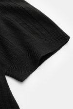 Close-up angled view of the sleeve of the 04651/ A trip in a bag Short sleeve knit polo 'Johnny' black showing its fine textured striped knit and ribbed band.

<p>Modern classic: This short sleeve knit polo by 04651/ A TRIP IN A BAG has a clean striped lo
