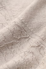 Nahaufnahme des 04651/ A trip in a bag Kurzarm-Strickpolo 'Hansen' hellgrau, sichtbar feiner Jacquard-Strick, Leinen-Baumwoll-Mix, leicht griffig, Oversized Fit, klassischer Polokragen, fotografiert aus schräger Perspektive.