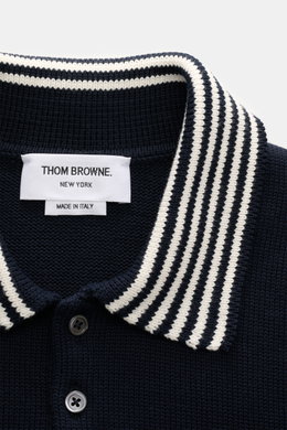 Nahaufnahme des Thom Browne Kurzarm-Strickpolo navy aus reiner Baumwolle, Regular Fit, mit gestricktem Polokragen und kontrastfarbenen Streifen, fotografiert von vorne.