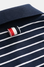 Nahaufnahme aus schräger Perspektive des Thom Browne Jersey-Poloshirts navy/weiß gestreift mit klassischem Polokragen, weichem Baumwoll-Jersey und markentypischem Streifenband am Kragen.
