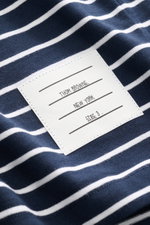 Nahaufnahme des Thom Browne Jersey-Poloshirts navy/weiß gestreift aus reiner Baumwolle, Fokus auf Label, weicher Griff, Jersey-Qualität.