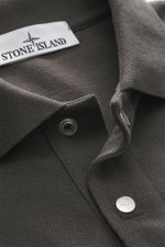 Close-up view of the Stone Island Polo shirt 'Stellina' dark grey collar, showing piqué made of pure cotton with a textured feel, garment dyed fabric, slim fit, typical polo collar, two-button placket with snap fasteners, and subtle Stellina stitching on 
