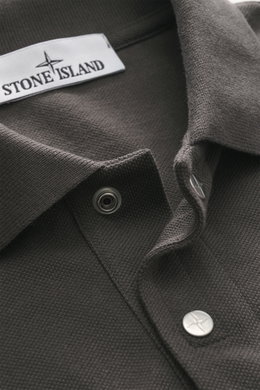 Close-up view of the Stone Island Polo shirt 'Stellina' dark grey collar, showing piqué made of pure cotton with a textured feel, garment dyed fabric, slim fit, typical polo collar, two-button placket with snap fasteners, and subtle Stellina stitching on 