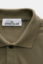 Stone Island Poloshirt oliv close-up from above, showing textured cotton piqué fabric, collar, button, and Stone Island label.
