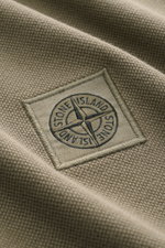 Close-up front view of the Stone Island Poloshirt oliv showing textured pure cotton piqué fabric and the stitched Stone Island Weblabel.

Description: <p>Das klassische Poloshirt ist ein Must-have in der sportiven Herrengarderobe: Aus Baumwoll-Piqué gef