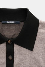 Nahaufnahme aus frontaler Perspektive des Jacquemus Merino Strickpolo 'Arlequin' taupe/graubraun meliert mit leicht elastischer Merinowolle, Regular Fit, farblich abgesetztem Polokragen, kontrastierenden Ärmeln, Logo-Stitching am Saum, farblich abgesetzte