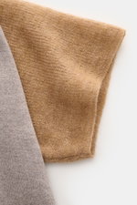 Close-up image of the sleeve and side detail of the Jacquemus Merino Knit Polo 'Arlequin' taupe/grey brown melange, photographed from the side, showing slightly elastic merino wool, regular fit, color-contrasted polo collar, sleeves in contrasting color a