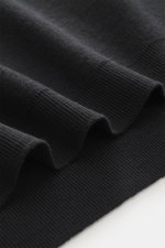 Nahaufnahme des schwarzen 04651/ A trip in a bag Poloshirt 'Wool TP' in Slim Fit, Piqué aus Baumwolle und Wolle, weicher Griff, klassischer Polokragen, glatte Drei-Knopf-Leiste, kleines Weblabel in der Seitennaht, komfortable Rippbündchen, Detailaufnahme 