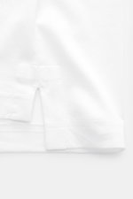 Stefan Brandt Jersey-Poloshirt 'Luca' weiß, Detailaufnahme der kurzen Saumschlitze, Slim Fit, Sea Island Baumwolle, weiche Haptik, Polokragen, Drei-Knopf-Leiste, leicht verlängerter Rücken.