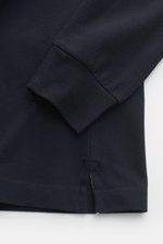 Close-up image of the hem and cuff of the Stone Island Longsleeve-Poloshirt dark navy, showing its garment-dyed, grippy piqué cotton fabric with slim fit and short side slits, photographed from above. Legere Kombinationen gelingen mit diesem klassischen L