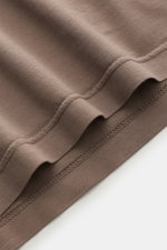 Nahaufnahme des taupefarbenen Saums vom Fedeli Jersey Longsleeve-Poloshirt 'Zero' aus glattem, seidigem Giza-Bio-Baumwoll-Jersey, seitliche Saumschlitze erkennbar.