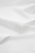 Gran Sasso Jersey Longsleeve-Poloshirt weiß aus Baumwoll-Jersey, Slim Fit, Haifischkragen, Drei-Knopf-Leiste, Sportmanschetten, seitliche Saumschlitze, Detailaufnahme Stoffstruktur.