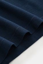 Nahaufnahme des navyfarbenen BRAUN Hamburg Longsleeve-Poloshirts aus weichem Baumwoll-Piqué, Detailansicht mit Haifisch-Kragen und Fünf-Knopf-Leiste.