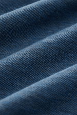 Nahaufnahme des graublauen Piqué-Jerseys vom BRAUN Hamburg Longsleeve-Poloshirt, Detail der feinen Baumwollstruktur aus schräger Perspektive.
