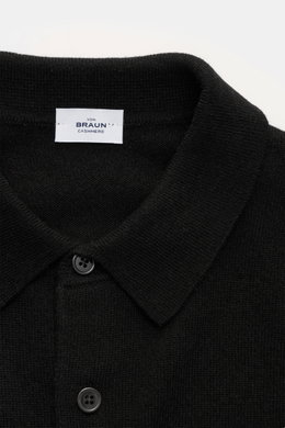 Nahaufnahme des von Braun Cashmere Strickpolo schwarz von oben, zeigt Polokragen, drei Knöpfe, feines Strickbild, Slim Fit und weichen Griff.