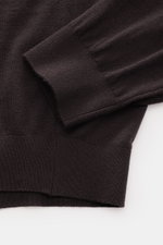 Nahaufnahme des von Braun Merino Strickpolo dunkelbraun mit offener Kragenleiste, elastischen Rippbündchen, feinem Strickbild, Regular Fit aus reiner Merinowolle.