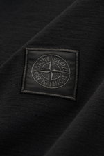 Nahaufnahme des tonalen Kompass-Logos auf dem Stone Island Longsleeve Jersey-Poloshirt 'Ghost Piece' schwarz aus leicht geflammtem Baumwolljersey.