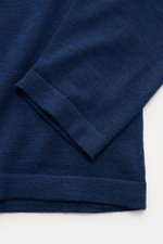 Nahaufnahme des Officine Générale Merino Strickpolo 'Bay' navy, seitlich fotografiert, mit weichem Griff, feinem Strickbild, Rippbündchen.