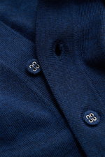 Nahaufnahme aus schräger Perspektive des Officine Générale Merino Strickpolo 'Bay' navy mit feinem Strickbild, Polokragen, Rippbündchen aus reiner Merinowolle.