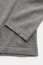Nahaufnahme des Officine Générale Merino Strickpolo 'Bay' grau meliert von schräg oben, reine Merinowolle, weicher Griff, feines Strickbild, Regular Fit, klassischer Polokragen, Rippbündchen.