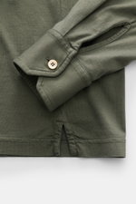 Nahaufnahme des Fedeli Jersey Longsleeve-Poloshirt 'Zero' graugrün von schräg oben, zeigt die klassische Sportmanschette mit Perlmuttknopf und seitlichen Saumschlitzen aus glattem, nachhaltigem Giza-Bio-Baumwolljersey.