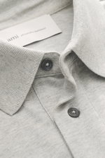 Close-up front view of the Ami Paris Jersey longsleeve polo shirt grey melange showing tailored collar, buttons, and soft cotton jersey fabric.

Description: <p>Contemporary casualness: With its generous oversized fit, the long sleeve polo shirt from AMI 