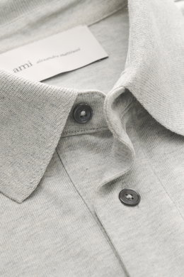 Close-up front view of the Ami Paris Jersey longsleeve polo shirt grey melange showing tailored collar, buttons, and soft cotton jersey fabric.

Description: <p>Contemporary casualness: With its generous oversized fit, the long sleeve polo shirt from AMI 