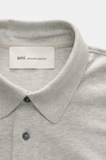 Close-up front view of Ami Paris Jersey longsleeve polo shirt grey melange showing tailored collar and buttons.

<p>Contemporary casualness: With its generous oversized fit, the long sleeve polo shirt from AMI PARIS becomes a relaxed key piece for spring 