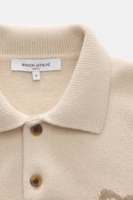 Maison Kitsuné Strickpolo sand, Nahaufnahme von oben, reines Wolle-Strickpolo mit Polokragen, Knopfleiste, Fuchs-Intarsienmotiv und Rippbündchen.