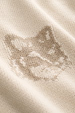 Nahaufnahme des Maison Kitsuné Strickpolo sand aus reiner Wolle mit markantem Fuchs-Intarsienmuster, weichem Griff und mittelfeinem Strickbild.