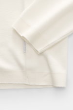 Nahaufnahme des Ärmels und Saums des cremefarbenen 04651/ A trip in a bag Longsleeve-Poloshirt 'Wool TP Polo LS' aus Baumwolle und Wolle mit strukturiertem Griff, Regular Fit, klassischem Polokragen, Drei-Knopf-Leiste, kleinem Weblabel in der Seitennaht u