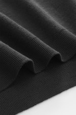 Nahaufnahme des schwarzen 04651/ A trip in a bag Longsleeve-Poloshirt 'Wool TP Polo LS' mit Jersey aus Baumwolle und Wolle, strukturiertem Griff, Regular Fit, klassischem Polokragen, Drei-Knopf-Leiste, kleinem Weblabel und komfortablen Rippbündchen, seitl