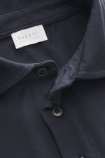 Nahaufnahme aus schräger Perspektive des Polokragens mit Knöpfen und Label des 04651/ A trip in a bag Longsleeve-Poloshirt 'WJ' navy, Mix aus Wolle und hochwertiger Microfaser, weicher Griff, Regular Fit, klassischer Polokragen, kurze Saumschlitze.