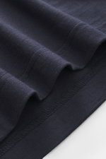 Nahaufnahme des navyfarbenen 04651/ A trip in a bag Longsleeve-Poloshirt 'WJ' von oben, zeigt weichen Griff, Regular Fit, Polokragen und kurze Saumschlitze, Mix aus Wolle und Microfaser.