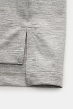 Nahaufnahme des Saums mit Saumschlitzen eines Thom Browne Rundhals-T-Shirts grau meliert aus schwerer, reiner Baumwolle mit weichem Griff, Slim Fit, hinten verlängert und flexiblen Rippbündchen, fotografiert von unten.