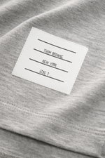 Nahaufnahme des Thom Browne Rundhals-T-Shirts grau meliert, schwerer Baumwollqualität mit Label und Saum, weicher Griff, Slim Fit, hinten verlängert.