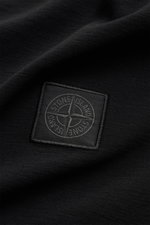 Stone Island Rundhals-T-Shirt 'Ghost Piece' schwarz, Nahaufnahme des tonalen Weblabels auf elastischem Baumwolljersey aus der Ghost Collection.