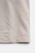 Nahaufnahme des Stone Island Rundhals-T-Shirts 'Ghost Piece' taupe, Slim Fit, aus elastischem Baumwolljersey mit tonalem Weblabel, aufgenommen von der Seitennaht unten.