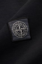 Nahaufnahme des Weblabels auf der Brust des Stone Island T-Shirts 'Dyed Regular Fit' schwarz aus reiner Baumwolle, weicher Griff, Regular Fit, Rundhalsausschnitt.