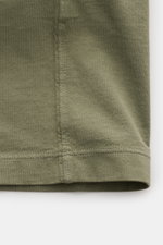 Nahaufnahme der Stoffstruktur und Saumnaht des Stone Island T-Shirts 'Dyed Regular Fit' oliv, reine Baumwolle, weicher Griff.