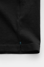 Close-up view of the lower hem side of the Fioroni Rundhals-T-Shirt schwarz, showing fine black knit, soft texture, slim fit with short side slits and delicate handmade stitchings.

Description: <p>Für den gediegenen Auftritt im Frühling sorgt dieses fein