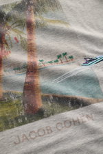 Close-up front view of Jacob Cohen Rundhals-T-Shirt 'Resort' grau meliert showing detailed palm print with boat embroidery and stitching.

<p>JACOB COHEN hat für seine 'Resort'-Kollektion unter anderem ein klassisches Palmen-Motiv gewählt, welches mit hoc