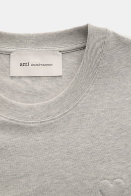 Close-up front view of the Ami Paris Rundhals-T-Shirt grau meliert showing the ribbed round neckline, soft grey melange cotton fabric, and subtle stitched heart logo, highlighting the heavy quality and soft touch. <p>Pardon my french - Mit diesem T-Shirt 