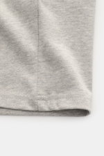 A close-up view of the hem and seam detail of the Ami Paris Rundhals-T-Shirt grau meliert, made from soft, heavy-quality pure cotton jersey with an oversized fit, round neckline, and stitched heart logo; photographed from the front lower edge. <p>Pardon m