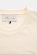 Ami Paris Rundhals-T-Shirt creme aus reiner Baumwolle mit weichem Griff, Regular Fit, Rundhalsausschnitt, geflocktem AMI PARIS-Schriftzug, Detailansicht von oben.