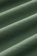Nahaufnahme der grünen Baumwollstruktur des B.F. Knitwear Rundhals-T-Shirts mit weichem Griff und feiner Strickqualität.