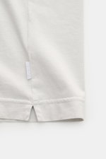 Detailaufnahme des Saum-Bereichs von 04651/ A trip in a bag Rundhals-T-Shirt hellgrau, Jersey aus reiner Baumwolle, weicher Griff, Regular Fit, Rundhalsausschnitt, kleines Weblabel sichtbar.